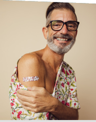 Older man age 50 or older showing off his band aid after being vaccinated