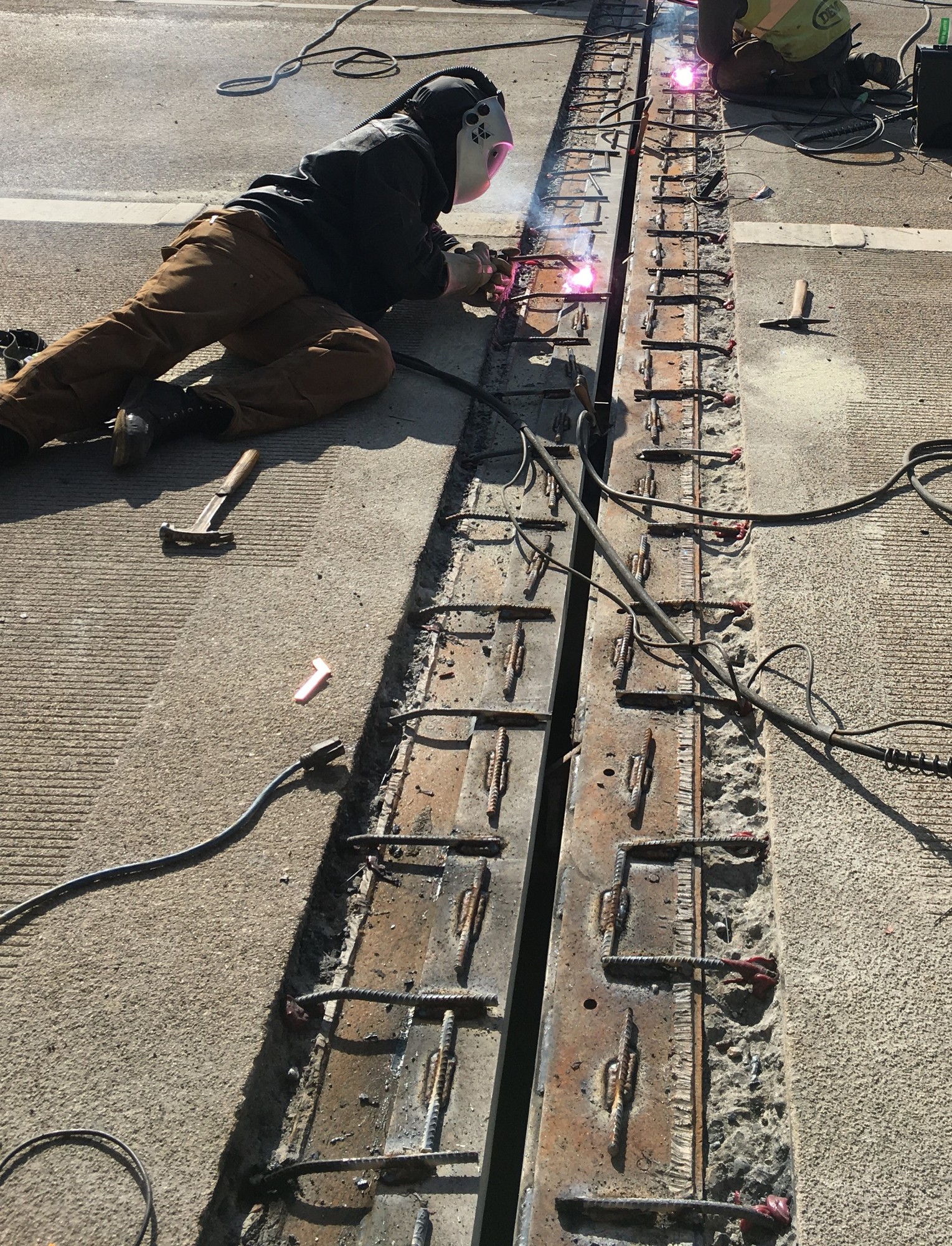 A welder places anchors for anew expansion joint