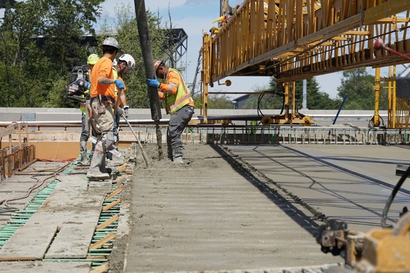 Crews pour concrete for the surface of the new eastbound SR 520 bridge.