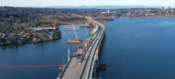 Photo shows drone photo, looking west, shows construction of a new, three-lane eastbound SR 520 bridge. 