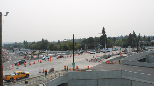 Photo shows Montlake Boulevard with construction cones/ongoing construction near WB entrance to 520. Cloudy sky in background. 