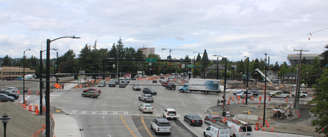 Shows northview of Montlake Boulevard. Cars are in the foreground with Montlake in the background and construction cones and materials
