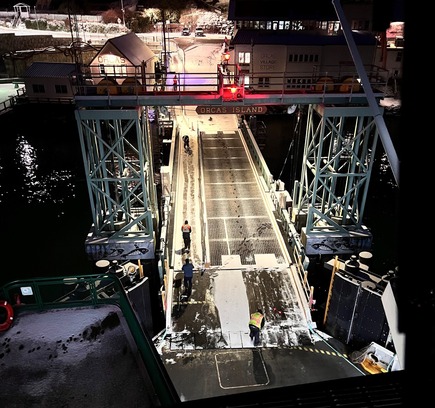 Ferry dock at Orcas Island at night with workers on a snowy ramp