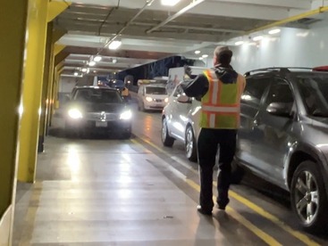 Ferry crew member directing on board onto the car deck