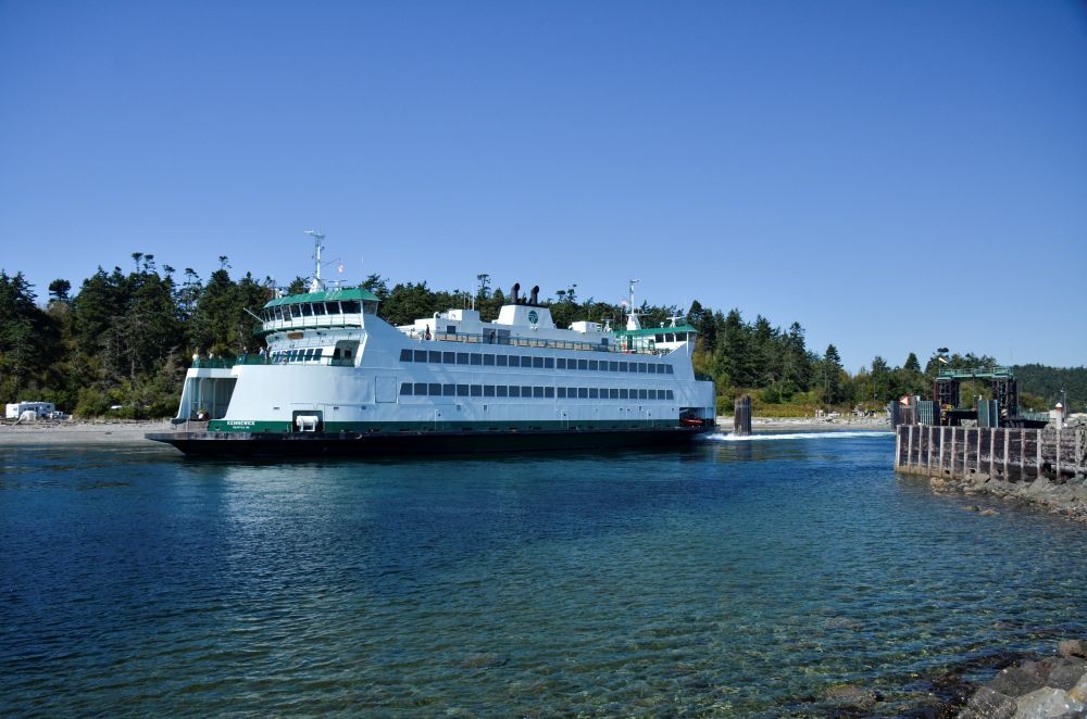 Ferry on the water near a wooded shoreline and a wooden dock in Keystone Harbor