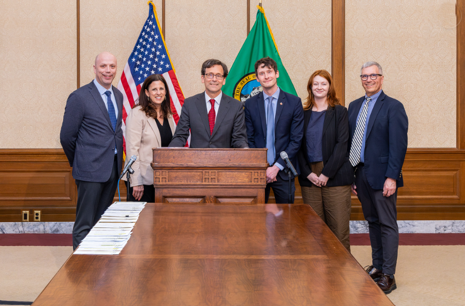 Steve Nevey gathers with Gov. Ferguson around a podium with some legislators for a bill signing