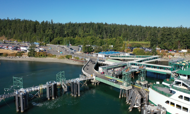 Aerial view of a Anacortes terminal with a docked ferry and surrounding forested landscape.