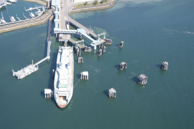 Aerial view of a ferry docked at Kingston terminal with surrounding piers and a nearby marina.