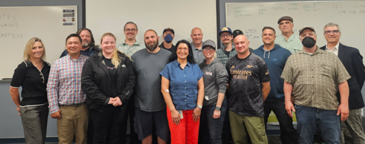 Group of people posing in front of whiteboards.