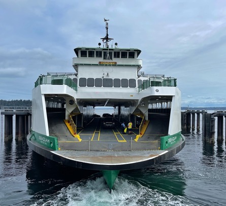 Front view of the Issaquah ferry docked at a pier with visible vehicles and crew members.