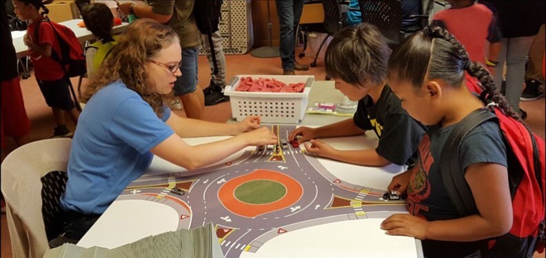Children learning how to navigate a roundabout at a South Central Region event