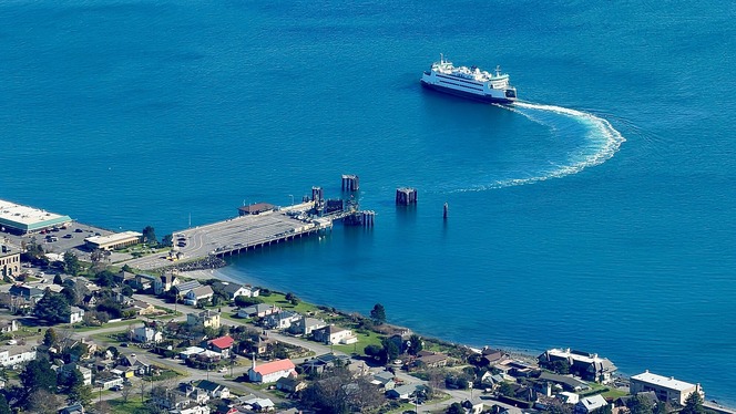 Aerial view of a ferry leaving Port Townsend terminal with nearby commercial and residential areas visible.