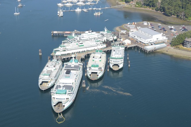 Aerial view of Eagle Harbor Maintenance Facility with multiple ferries docked and surrounding buildings.