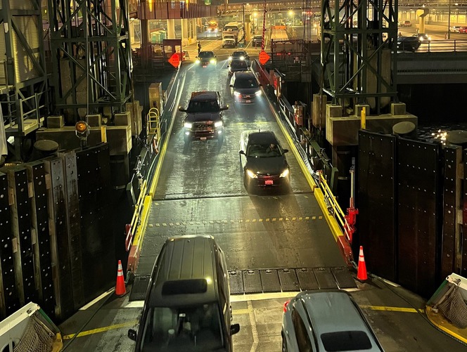 Vehicles boarding a ferry at night at Seattle's Colman Dock.