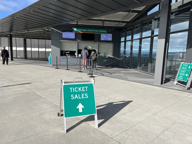 Ticket booths at Colman Dock with a "TICKET SALES" sign in the foreground.