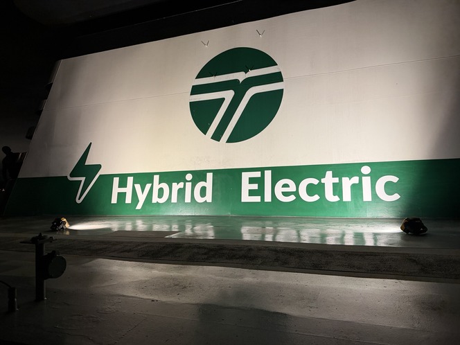 Ferry's smokestack with "Hybrid Electric" text and lightning bolt symbol beneath a WSDOT logo.