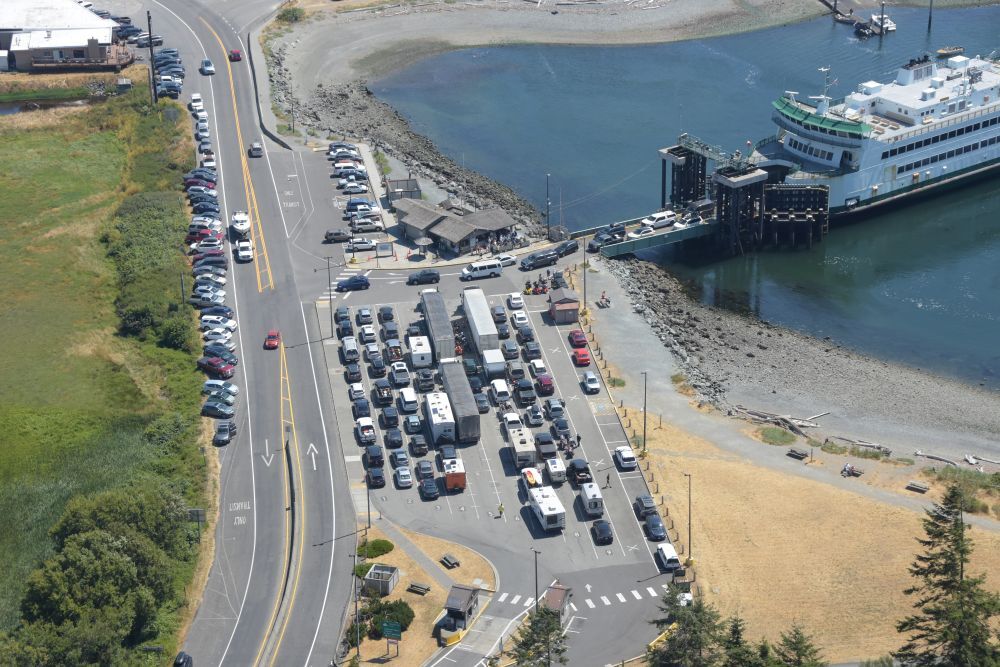 Aerial view of a Coupeville terminal with vehicles in holding lanes and a ferry docked at the waterfront.