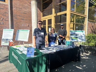 People standing at info table outside building 
