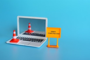 Traffic cones and a construction team on a laptop computer.