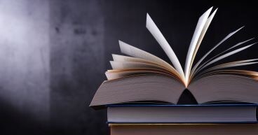 Books stacked in front of a gray background
