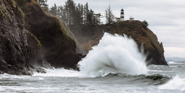 water crashing against rock below lighthouse