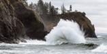 water crashing against rock below lighthouse