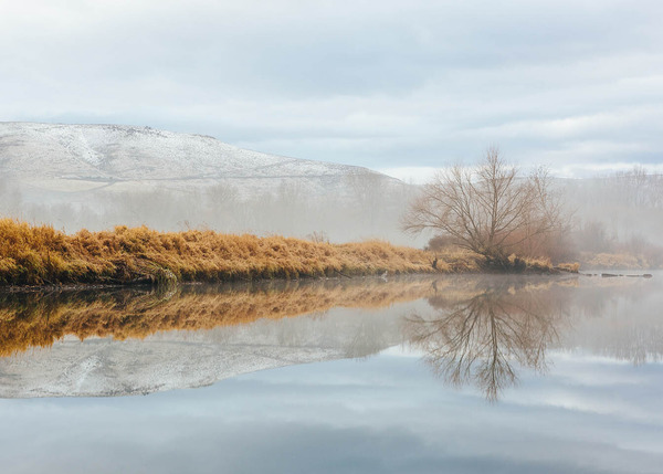 Snowy winter hills reflected in the river outside Ellensburg