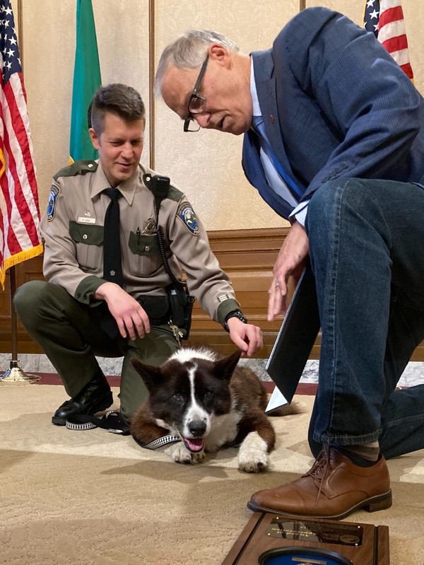 Gov. Jay Inslee acknowledges WDFW K9 Colter and his handler, Officer Nick Jorg, for 14 years of state service.