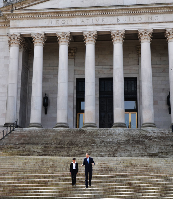 Justice Mary Yu and Gov. Jay Inslee walk down the steps of the Legislative Building