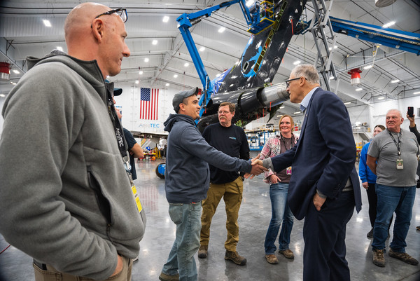 Gov. Jay Inslee greets aircraft maintenance technicians working at Grant County International Airport during a visit to Moses Lake.