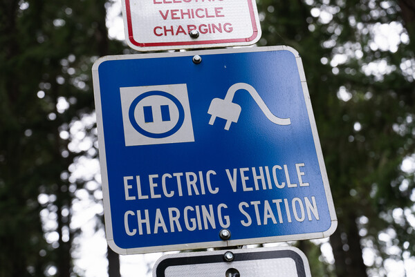 A blue sign reads "Electric Vehicle Charging Station"