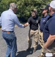 Inslee shakes hands and speaks with a small group of men involved with the firefighting response