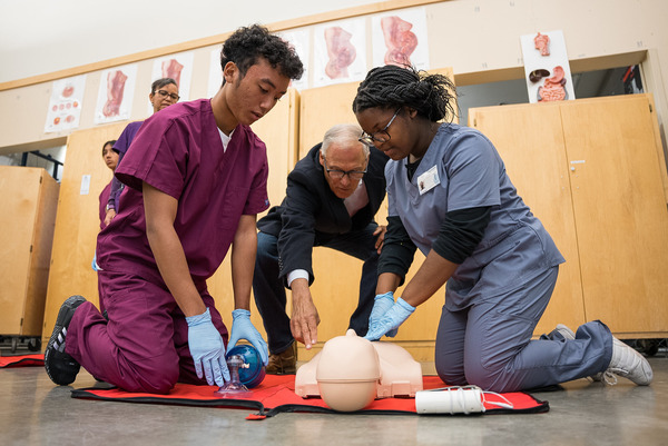 Gov. Jay Inslee lends a hand with chest compressions in a health careers classroom at Mount Tahoma High School.