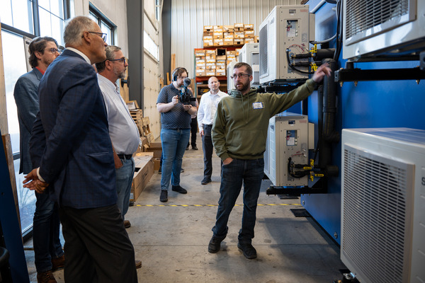 A worker shows Gov. Jay Inslee custom-fitted heat pumps for industrial use.