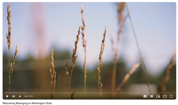 A Screenshot of the video "Welcoming Belonging to Washington State." A closeup of a field with a natural background is shown.