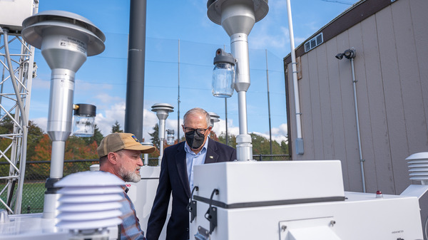 Gov. Jay Inslee is shown the interface of a new air quality monitoring station in Seattle’s Beacon Hill neighborhood.