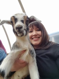 Heidi Helsley smiling while holding a goat with a cute face
