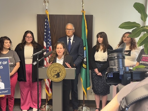 Photo of woman at podium in front  of a group of people