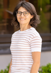 Laura Villegas wearing glasses and a striped shirt