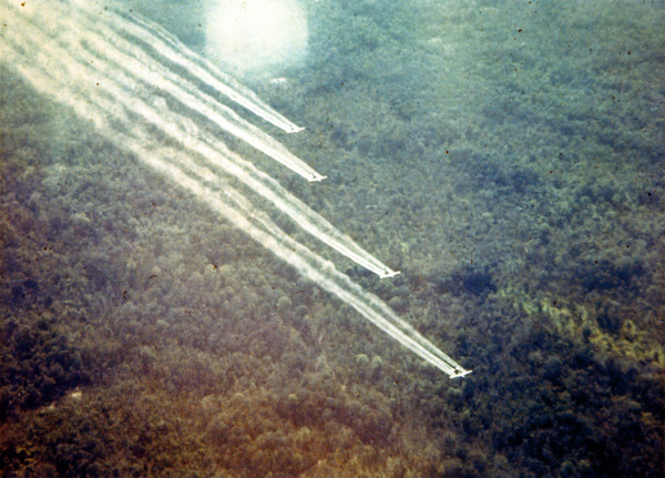 Four planes spray defoliant over the jungle during the Vietnam War