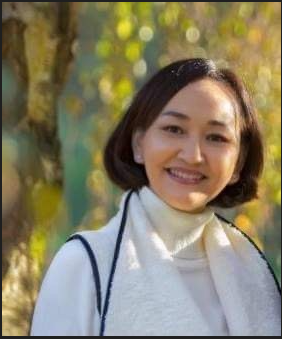 Nadia Damchii standing in the sun wearing a white sweater