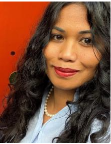 Joanne Lee wearing a light blue blouse and pearl necklace