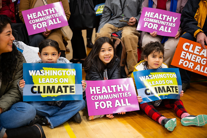 Photo of kids holding placards that say WA leads on climate