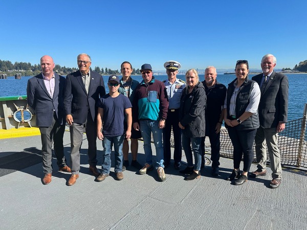 A group of Washington State Ferries workers stands on deck for a photo