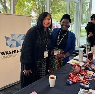 Teddy and Joann Lee smiling while working at resource table