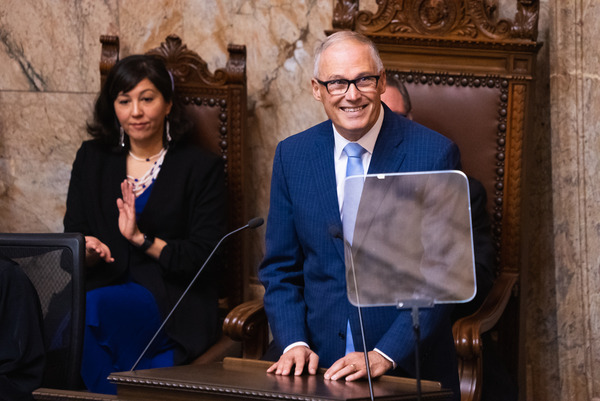 Gov. Jay Inslee smiles from a podium