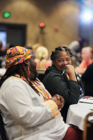 Two Black people sharing a laugh together as they participate in a workbook event.