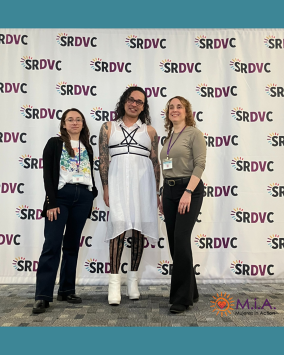 Group of people posing in front of step and repeat.