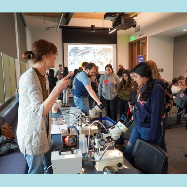 Volunteer from Washington Department of Ecology walks student through activity.