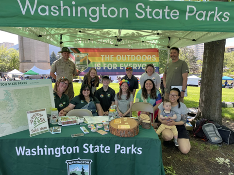 Washington State Parks employees smiling at state parks booth at pride event